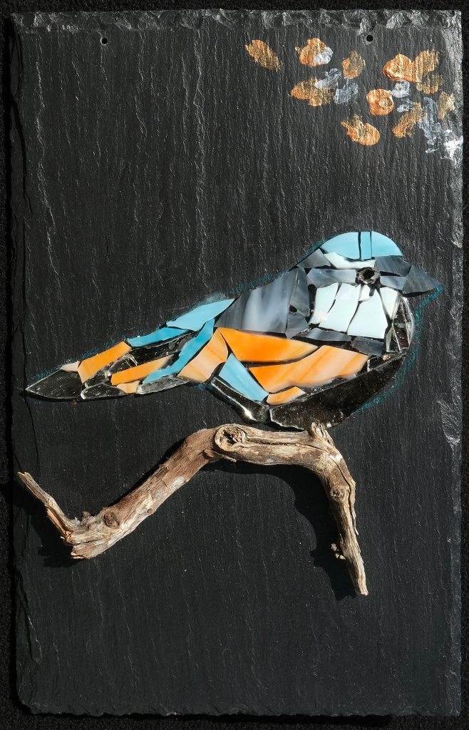 Oiseau coloré en verre fragmenté sur bois flotté sans joint